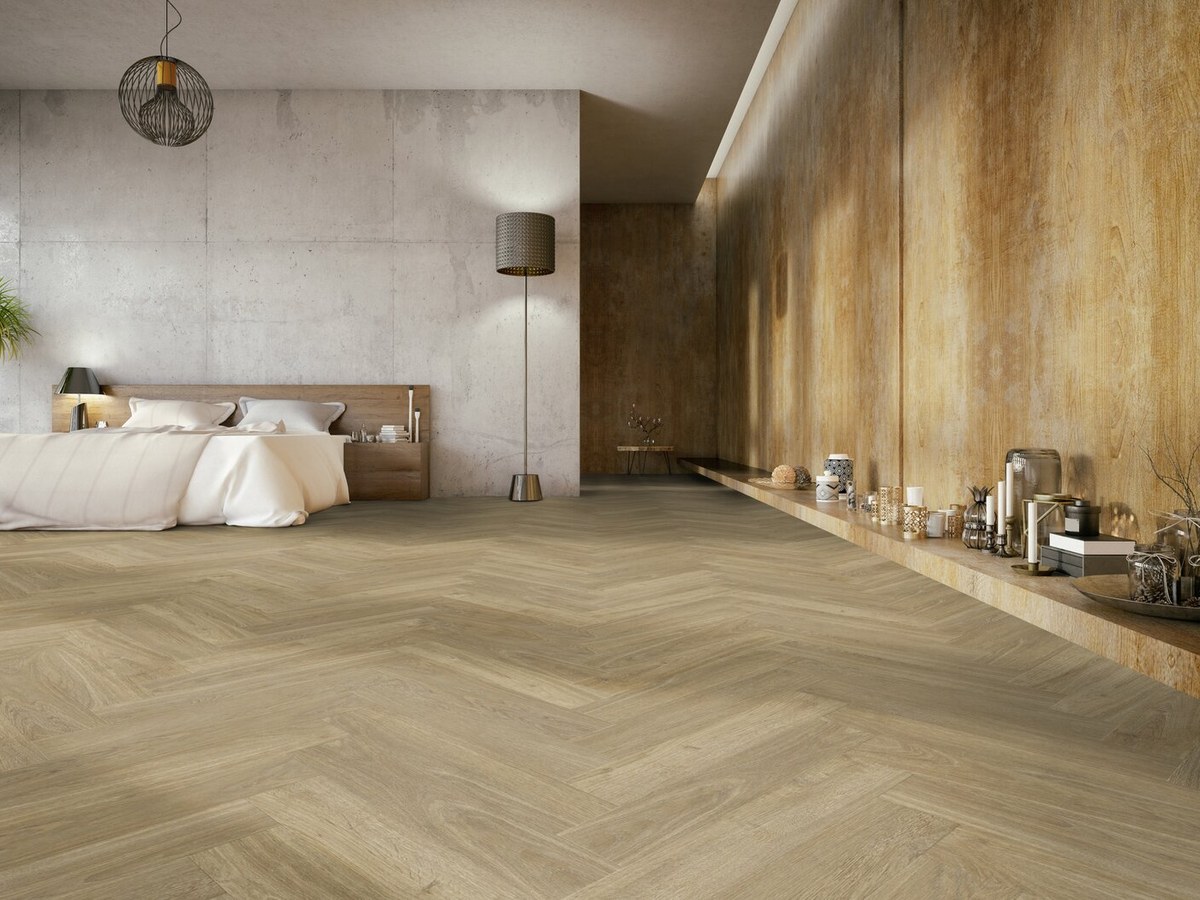 Sol effet chêne posé en chevrons dans une chambre lumineuse aux murs béton et bois
